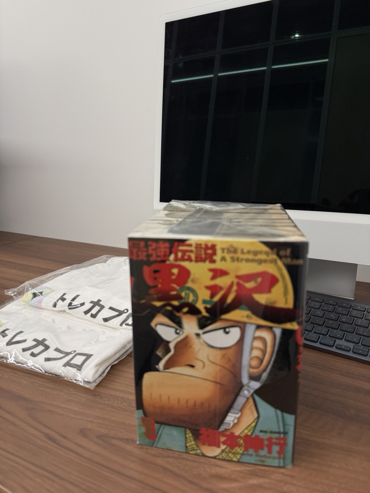 トレカプロ デスクの様子。社名入りTシャツと愛読の漫画